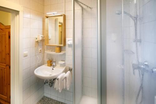 a bathroom with a shower, sink, and toilet at Hotel Rosi in Regensburg