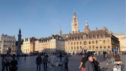 a group of people walking in front of a large building at Appartement Héloïse, le charme du Vieux-Lille in Lille