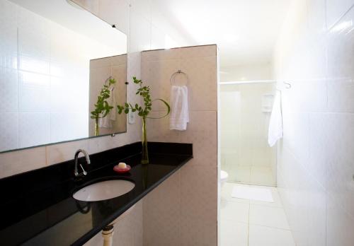 a bathroom with a sink and a shower at Pousada dos Gravatais in Marataizes