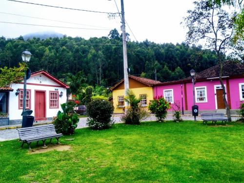 a park with two benches in front of houses at Chales do Antonio in São Pedro da Serra