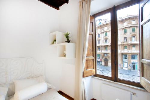 a white room with a window and a white bed and a window at Arenula Luxury Apartment in Rome