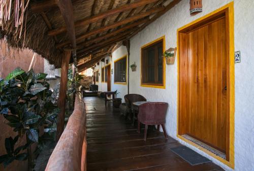 a hallway of a house with a wooden door and chairs at Villas Margaritas Holbox in Holbox Island
