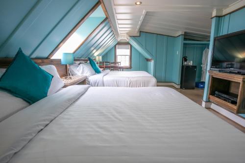 a bedroom with two beds and a fireplace at Auberge Seigneurie des Monts in Sainte-Anne-des-Monts