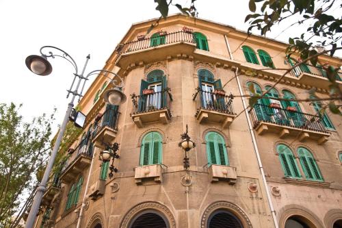 a building with green windows and balconies on it at B&B Lepanto in Messina