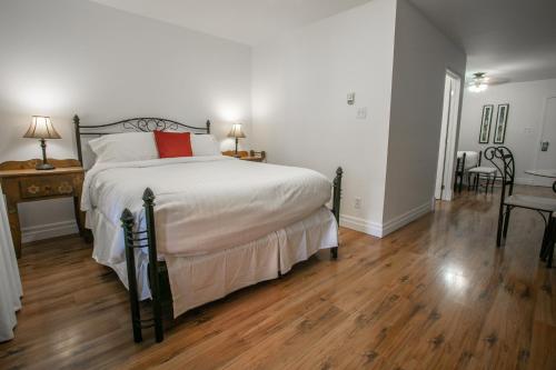 a bedroom with a large bed and a wooden floor at Auberge Seigneurie des Monts in Sainte-Anne-des-Monts
