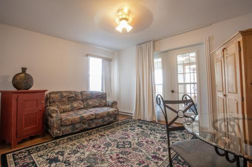 a living room with a couch and a chair at Auberge Seigneurie des Monts in Sainte-Anne-des-Monts