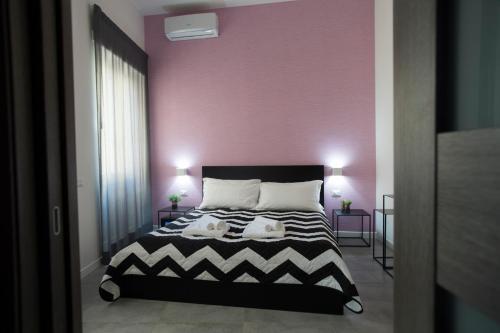 a bedroom with a pink wall and a bed at LECENTRE 174 in Salerno
