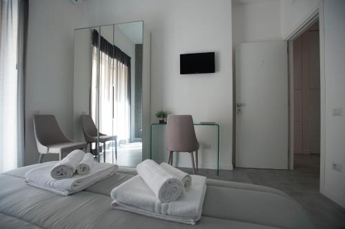 a white bedroom with a bed and a mirror at LECENTRE 174 in Salerno