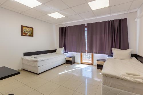 a room with two beds and a couch and a window at СТАИ ЗА ГОСТИ ХАН КРУМ in Burgas City