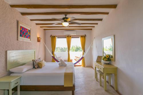 a bedroom with a bed and a ceiling fan at Villas Margaritas Holbox in Holbox Island