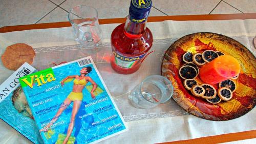 a table with a magazine and a pizza and a book at Korona Apartments in Vathi, Ithaka