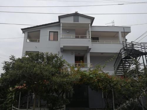 a white apartment building with a spiral staircase at Villa Osmani in Durrës