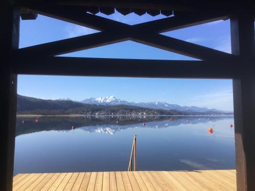a view of a lake from a window at Villa Auguste in Pörtschach am Wörthersee
