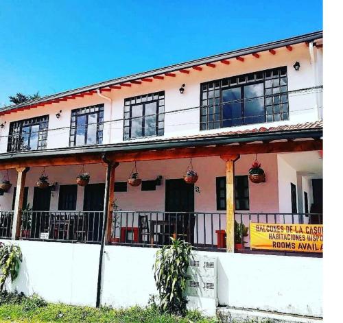 a white building with windows and a sign on it at Balcones de la Casona in Guatapé