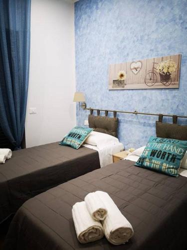 a hotel room with two beds with towels on them at Beb oasi marina in Campofelice di Roccella