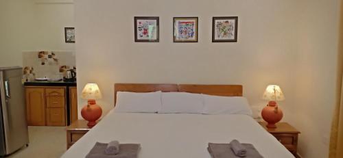 a bedroom with a large bed with two lamps at Primavera Holiday Homes-FAMILY RUN GOAN GUEST HOUSE in Candolim
