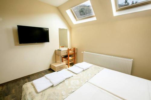 een slaapkamer met een bed en een flatscreen-tv bij Апартамент Радост Сандански in Sandanski