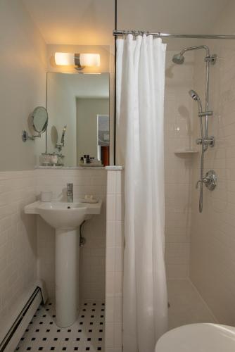 a bathroom with a white shower curtain and a sink at Liberty Hill Inn in Yarmouth