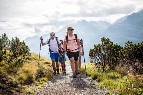 a man and a woman walking on a mountain trail at Pension der Steinbock - das 300 Jahre alte Bauernhaus - TIROL in Sankt Anton am Arlberg