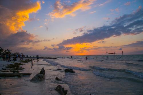a group of people on the beach at sunset at Villas Margaritas Holbox in Holbox Island