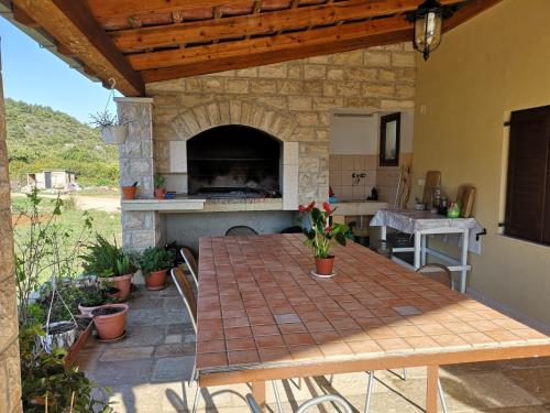 um pátio exterior com uma mesa e um forno de pedra em Holiday Home Cvitka em Vis