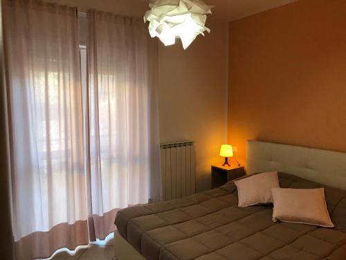 a bedroom with a bed with a lamp and a window at Cà Giorg in Fanano