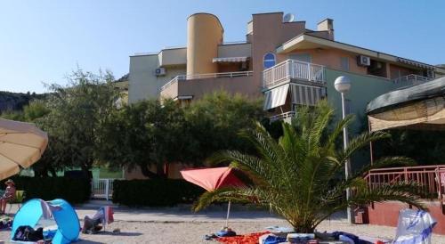 un resort con una palma e un edificio di Apartman LOZA a Klek