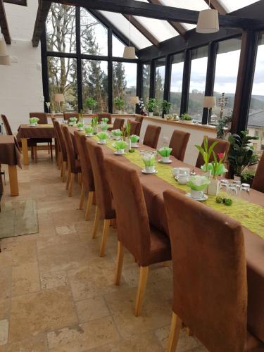 Hotel Feldmaus في Olzheim: غرفة طعام طويلة مع طاولة وكراسي طويلة