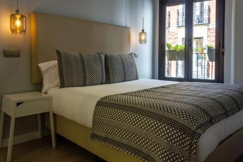 1 dormitorio con 1 cama grande y ventana en Arenal Suites Puerta del Sol, en Madrid