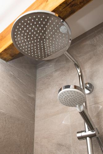 a shower with a shower head in a bathroom at Your Home - City Apartment in Kufstein in Kufstein