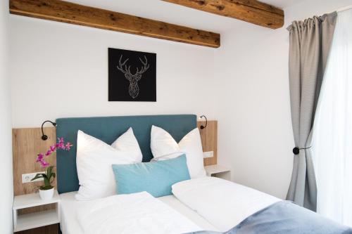 a bedroom with a bed with white and blue pillows at Your Home - City Apartment in Kufstein in Kufstein