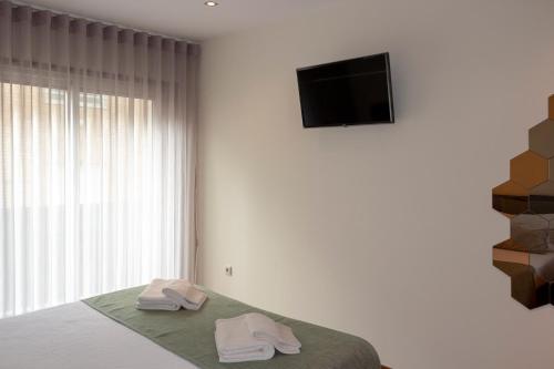 1 dormitorio con 1 cama con 2 toallas en Apartamento Latino Coelho, en Póvoa de Varzim