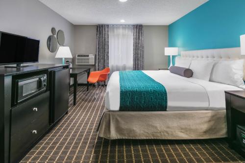 Habitación de hotel con cama grande y escritorio. en Howard Johnson by Wyndham Near Schlitterbahn, en New Braunfels