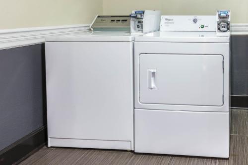 a white refrigerator and a washer and dryer in a room at Howard Johnson by Wyndham Near Schlitterbahn in New Braunfels