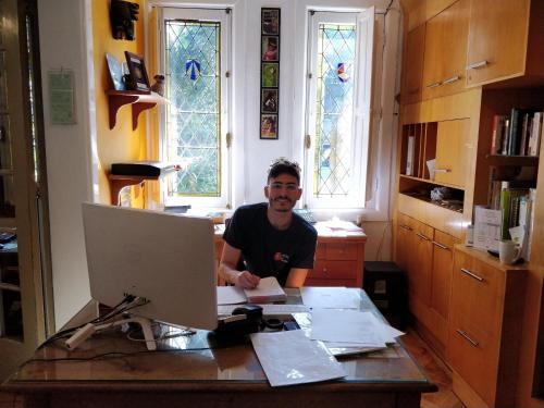 a man sitting at a desk with a computer at Hostal Rio Amazonas in Santiago