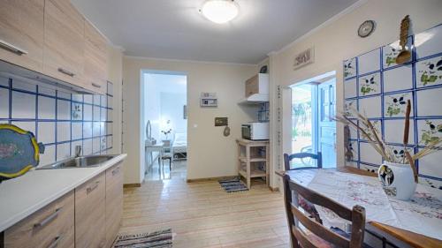 uma cozinha com um lavatório e uma mesa num quarto em Feakia apartment 2 em Agios Gordios