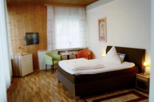 een hotelkamer met een bed en een stoel bij Hotel-Cafe Maxx in Lengerich