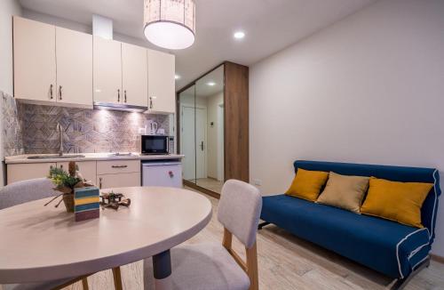 Nino's Rooms في غودواري: غرفة معيشة مع أريكة زرقاء وطاولة