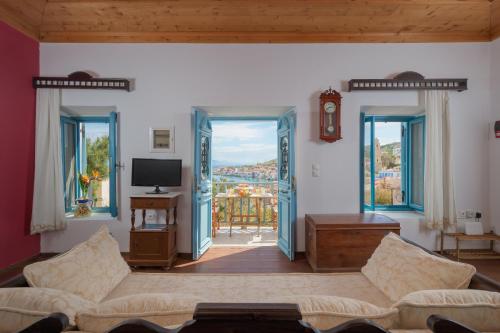 een woonkamer met een bank en een tv bij Villa Katingo in Halki