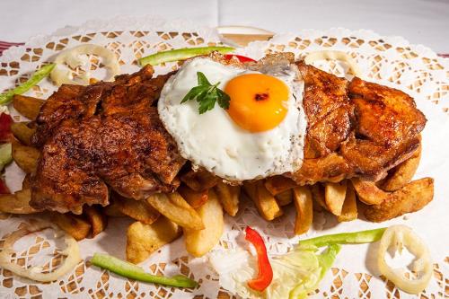 a plate of food with an egg and french fries at Lion Prémium in Budapest