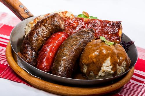 a plate of food with sausages and other foods at Lion Prémium in Budapest