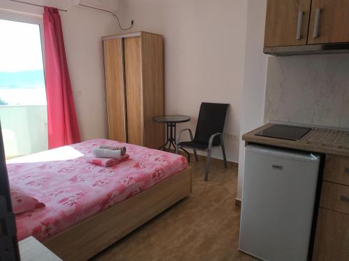 a small bedroom with a bed and a table at Alise in Bar