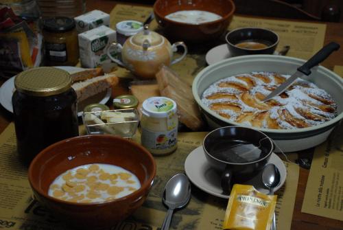 einen Tisch mit Schalen und Teller mit Lebensmitteln in der Unterkunft Fattoria Nonno Neno B&B in Appignano