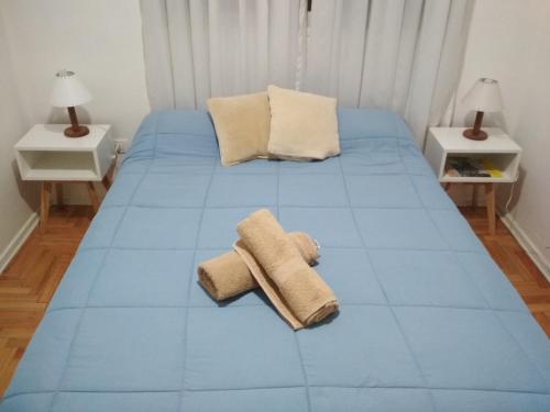 a blue bed with towels on it in a room at Apartment City Center Recoleta in Buenos Aires