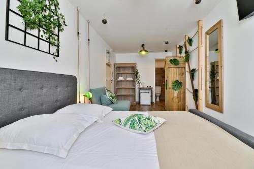 a bedroom with a white bed with a gray headboard at H&ocirc;tel La Bastide in Hy&egrave;res