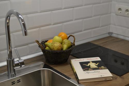 un cesto di frutta su un bancone della cucina con un libro di El Librero de La Alhambra a La Zubia