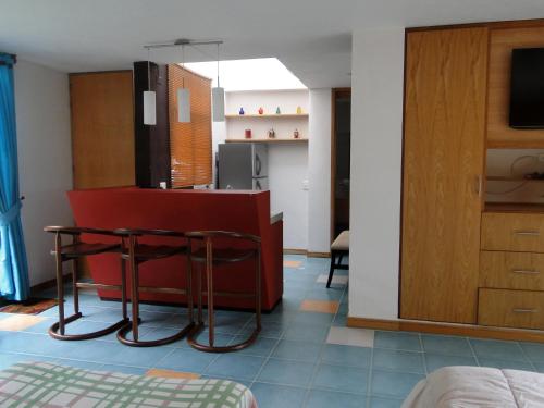 a living room with a red counter and a kitchen at Hotel Familiar El Remanso Del Agua in Guatapé