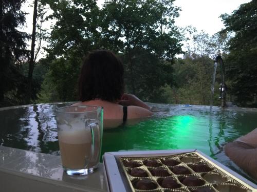 a woman sitting in a swimming pool with a drink at VIP Red Love house for 2 in Shilagalyay