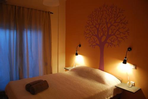 ein Schlafzimmer mit einem Bett mit einem Baum an der Wand in der Unterkunft Lake view apartment in Ioannina