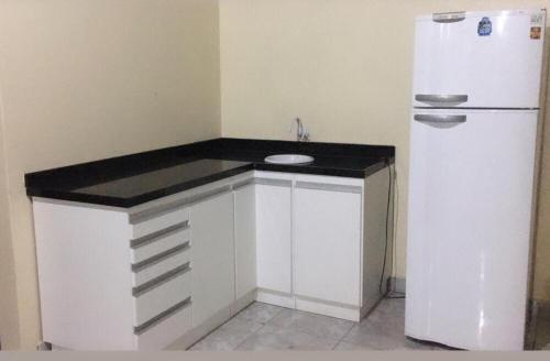 a kitchen with a counter and a refrigerator at Hotel Solar Flores in Alegrete